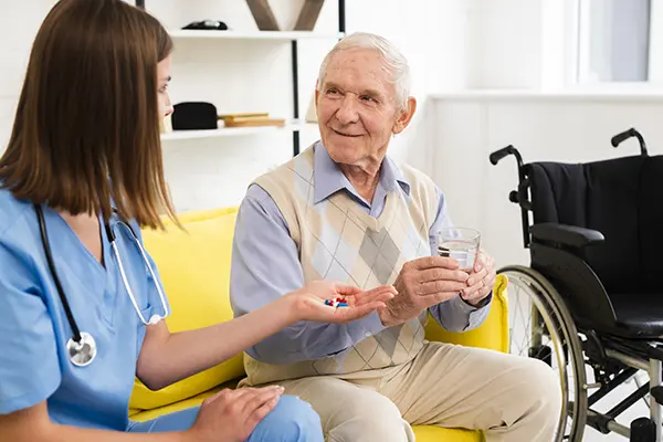 Nurse giving elderly man his medicine